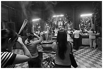 Worshipping at altar with  Jade Emperor and Four Big Diamonds, Chua Ngoc Hoang, district 3. Ho Chi Minh City, Vietnam (black and white)