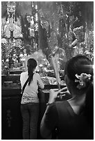Women holding incense sticks, Phuoc Hai Tu pagoda, district 3. Ho Chi Minh City, Vietnam ( black and white)