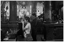 Couple worshipping Thang Hoang, Chua Ngoc Hoang pagoda, district 3. Ho Chi Minh City, Vietnam (black and white)