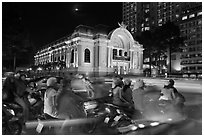 Motorbikes and colonial-area Opera House at night. Ho Chi Minh City, Vietnam (black and white)