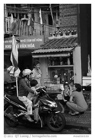 Neighborhood chat in front of street altar. Ho Chi Minh City, Vietnam (black and white)