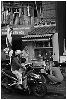 Neighborhood chat in front of street altar. Ho Chi Minh City, Vietnam (black and white)