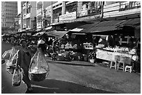 Woman carrying goods on street market. Ho Chi Minh City, Vietnam ( black and white)