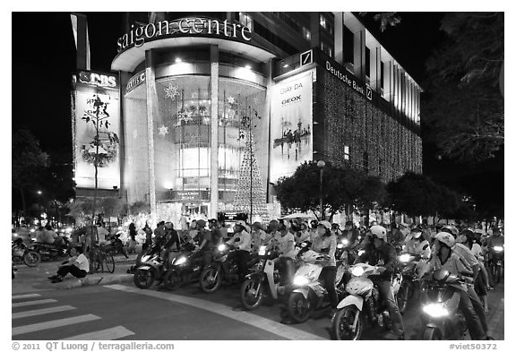 Dense motorcycle traffic in front of Saigon Center at night. Ho Chi Minh City, Vietnam (black and white)