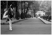 Woman plays badminton using feet (footbag), Cong Vien Van Hoa Park. Ho Chi Minh City, Vietnam (black and white)