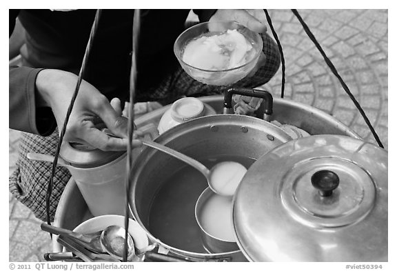 Sirup added to a bowl of soft tofu. Ho Chi Minh City, Vietnam (black and white)