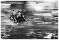 Motorcycle riders, water splashes, and streaks of light. Ho Chi Minh City, Vietnam (black and white)