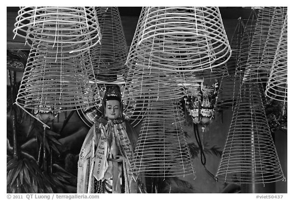 Porcelain figure and incense coils, Phuoc An Hoi Quan Pagoda. Cholon, District 5, Ho Chi Minh City, Vietnam (black and white)