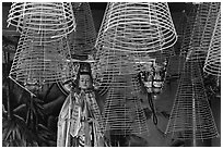 Porcelain figure and incense coils, Phuoc An Hoi Quan Pagoda. Cholon, District 5, Ho Chi Minh City, Vietnam ( black and white)