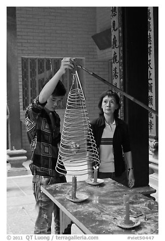 Man getting ready to hang incense coil, Thien Hau Pagoda, district 5. Cholon, District 5, Ho Chi Minh City, Vietnam