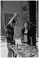 Man getting ready to hang incense coil, Thien Hau Pagoda, district 5. Cholon, District 5, Ho Chi Minh City, Vietnam ( black and white)