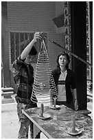 Man getting ready to hang incense coil, Thien Hau Pagoda, district 5. Cholon, District 5, Ho Chi Minh City, Vietnam (black and white)