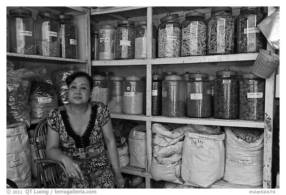 Woman with jars of traditional medicinal supplies. Cholon, Ho Chi Minh City, Vietnam (black and white)