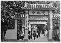 People walking through gates, Giac Lam Pagoda, Tan Binh District. Ho Chi Minh City, Vietnam ( black and white)