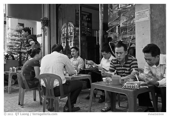 Men eating breakfast on the street. Ho Chi Minh City, Vietnam (black and white)