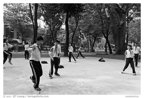 Schoolboys playing a feet badminton game, Cong Vien Van Hoa Park. Ho Chi Minh City, Vietnam (black and white)