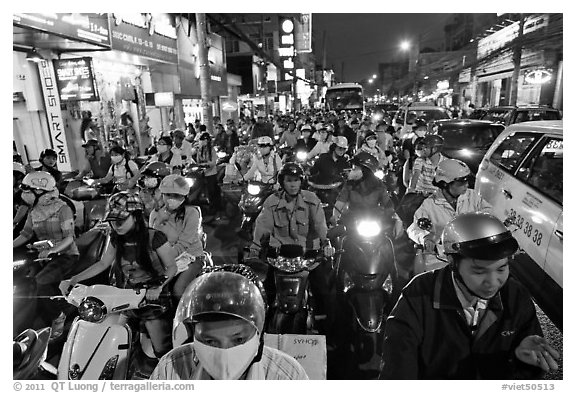 Street packed with motorcycles and vehicles at dusk. Ho Chi Minh City, Vietnam (black and white)