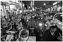Street packed with motorcycles and vehicles at dusk. Ho Chi Minh City, Vietnam ( black and white)