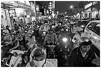 Street packed with motorcycles and vehicles at dusk. Ho Chi Minh City, Vietnam (black and white)