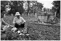 Women burning fake money as offering. Ben Tre, Vietnam (black and white)