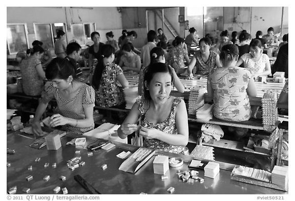 Workers wrapping up coconut candy. Ben Tre, Vietnam