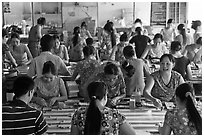 Women packing coconut candy in factory. Ben Tre, Vietnam (black and white)