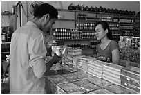 Customer buying box of coconut candy. Ben Tre, Vietnam (black and white)