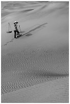 Woman with yoke baskets on sands. Mui Ne, Vietnam (black and white)