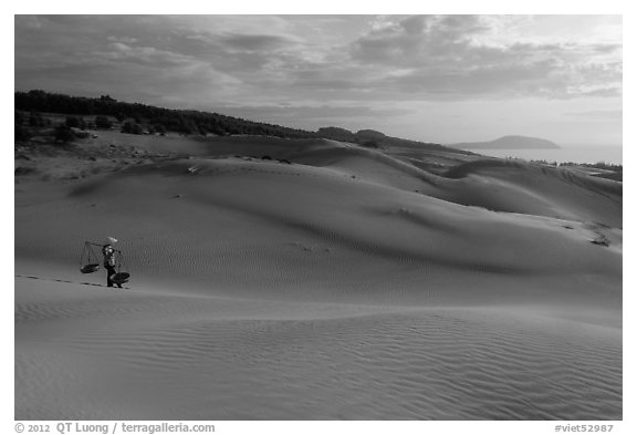 Coastal sand dunes with sea in distance and local woman. Mui Ne, Vietnam (black and white)