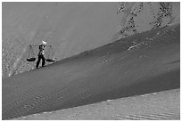 Woman ascending dune ridge with two baskets. Mui Ne, Vietnam ( black and white)