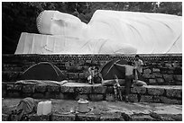 Pilgrims pitch tent below reclining Buddha statue. Ta Cu Mountain, Vietnam (black and white)