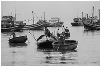 Men use round woven boats to disembark from fishing boats. Mui Ne, Vietnam (black and white)