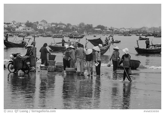 Fishing activity reflected on wet beach. Mui Ne, Vietnam (black and white)