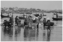 Fishing activity reflected on wet beach. Mui Ne, Vietnam (black and white)