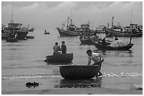 Fishermen on roundboats and fishing fleet. Mui Ne, Vietnam (black and white)