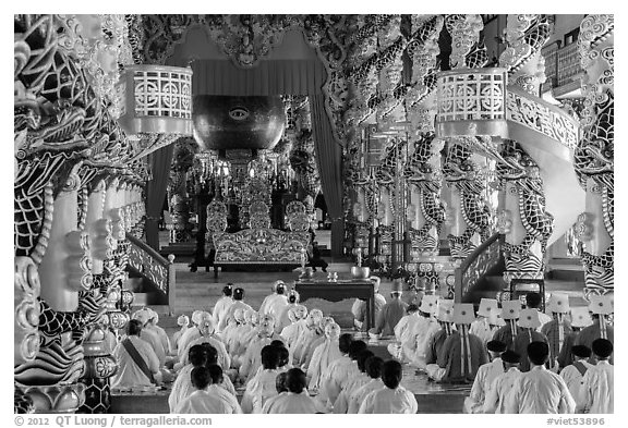 Dignitaries (in colored robes) and other followers praying at the Main hall, Cao Dai temple. Tay Ninh, Vietnam (black and white)