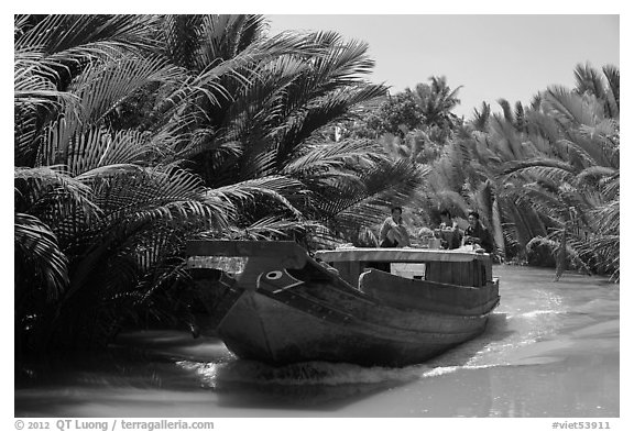 Boat navigating narrow waterway, Phoenix Island. My Tho, Vietnam (black and white)