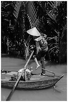 Woman standing in canoe on jungle canal, Phoenix Island. My Tho, Vietnam (black and white)