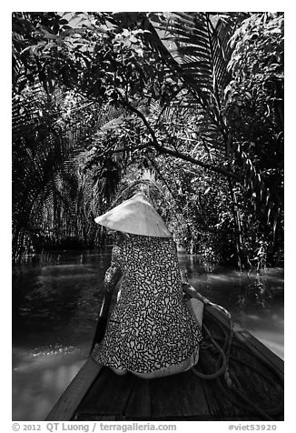 Woman rowing boat under jungle canopy, Phoenix Island. My Tho, Vietnam (black and white)