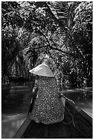 Woman rowing boat under jungle canopy, Phoenix Island. My Tho, Vietnam (black and white)