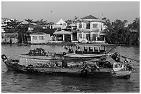 People moving pinapples from boat to boat on river. Can Tho, Vietnam (black and white)