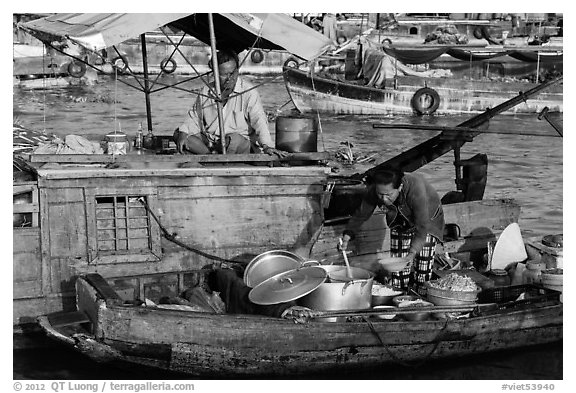 Woman serving food across boats, Cai Rang floating market. Can Tho, Vietnam (black and white)