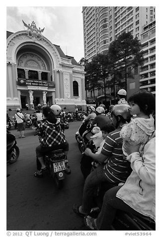 Family on motorbike watching performance at opera house. Ho Chi Minh City, Vietnam (black and white)