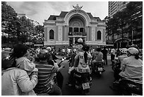 Families gather on motorbikes to watch performance in front of opera house. Ho Chi Minh City, Vietnam (black and white)