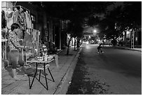 Woman tends to altar on street at dusk. Hoi An, Vietnam ( black and white)