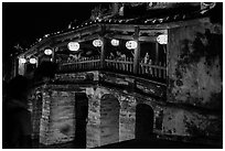 People enjoy Japanese Bridge lit solely by lanterns. Hoi An, Vietnam (black and white)