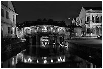 Covered Japanese Bridge reflected in canal by night. Hoi An, Vietnam (black and white)