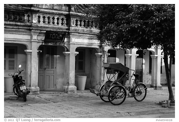 Motorcyle and cyclo in front of old townhouses. Hoi An, Vietnam (black and white)