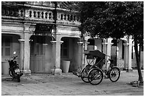Motorcyle and cyclo in front of old townhouses. Hoi An, Vietnam (black and white)