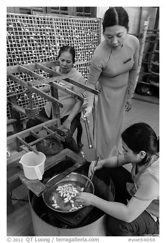 Workers demonstrate silkworm processing. Hoi An, Vietnam (black and white)